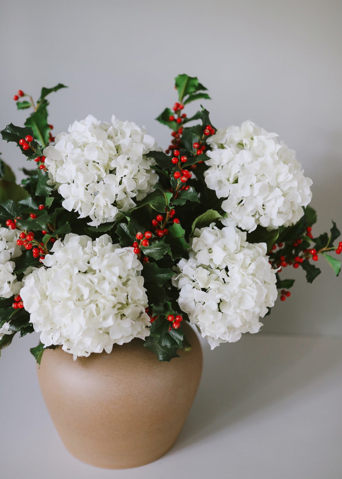 White Hydrangeas Arranged with Red Holly Stems