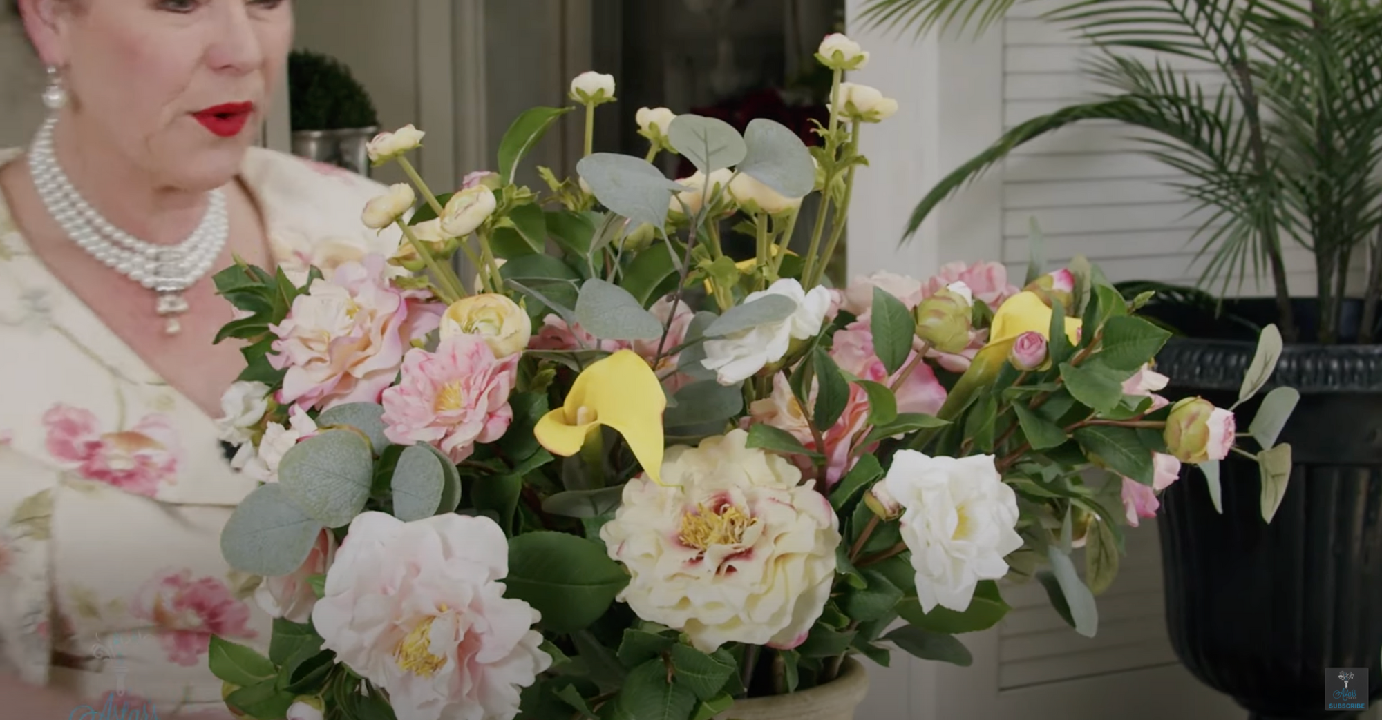 A Pink and white Camellia design with Eucalyptus, Yellow Calla and Ranunculas