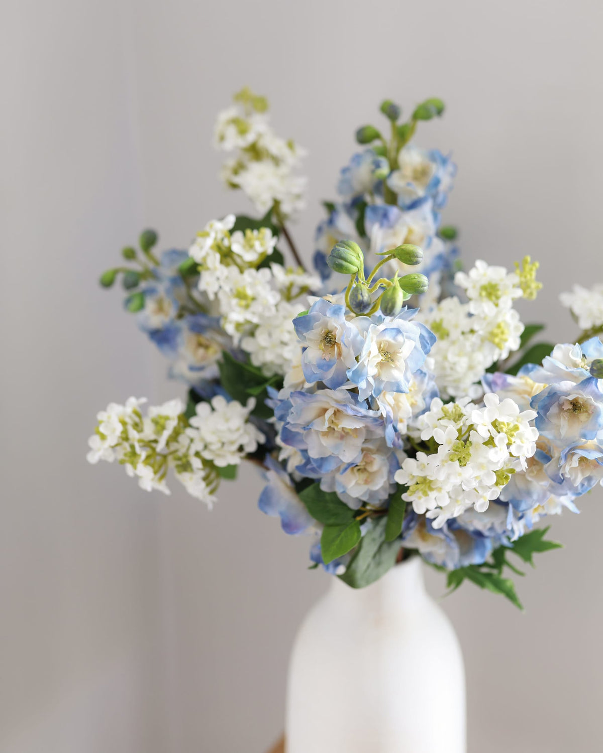 artificial real touch blue delphiniums and lilac in a vase 