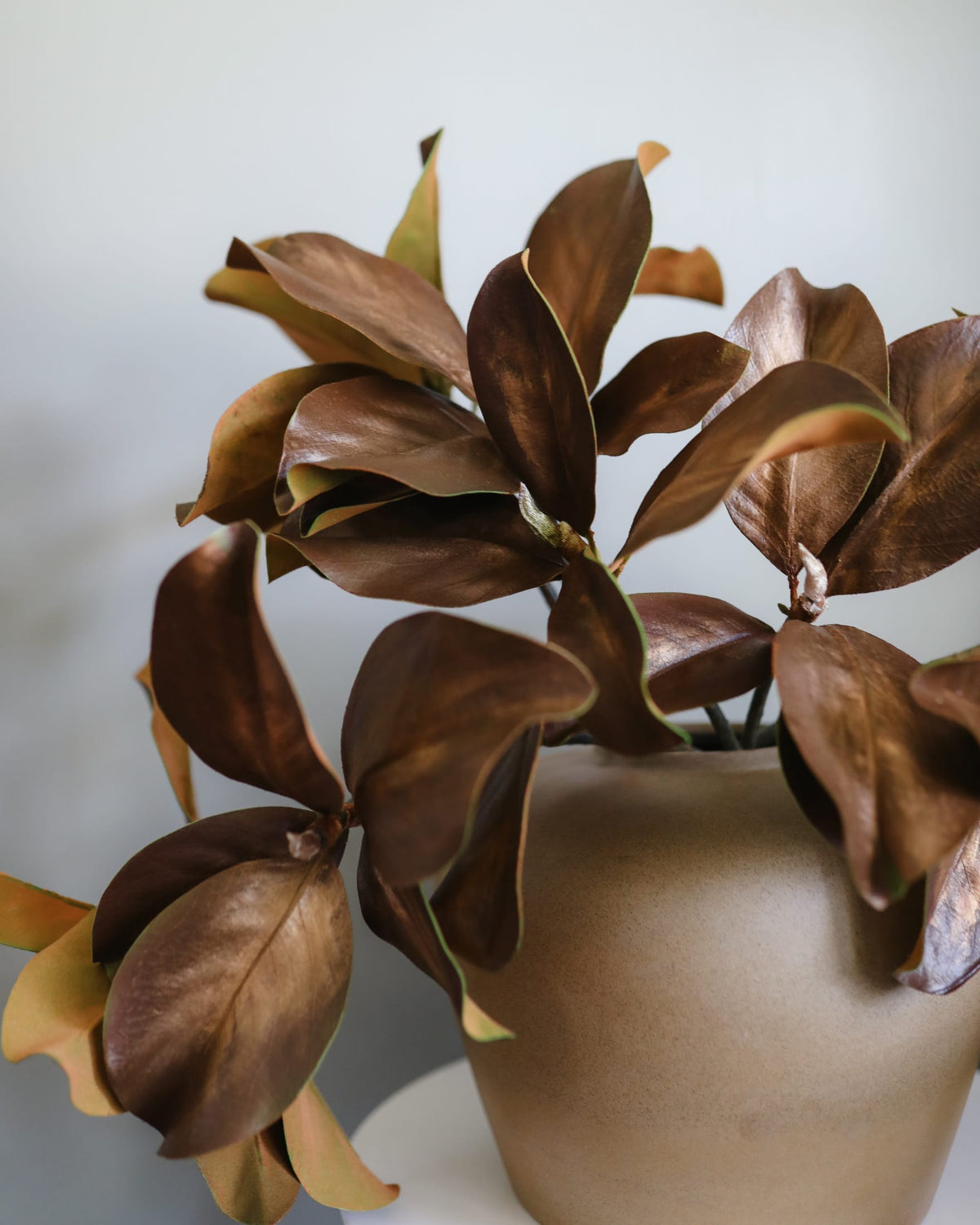 Bronze-colored faux magnolia in a vase