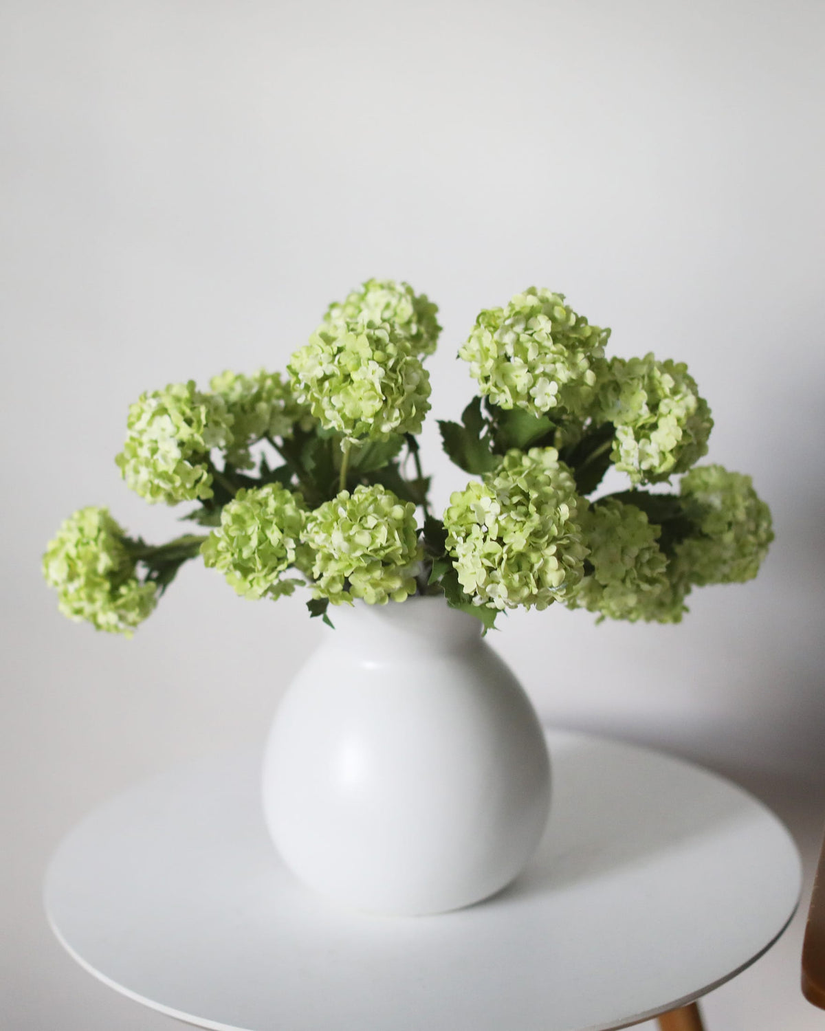 Faux Green Snowballs in a white vase