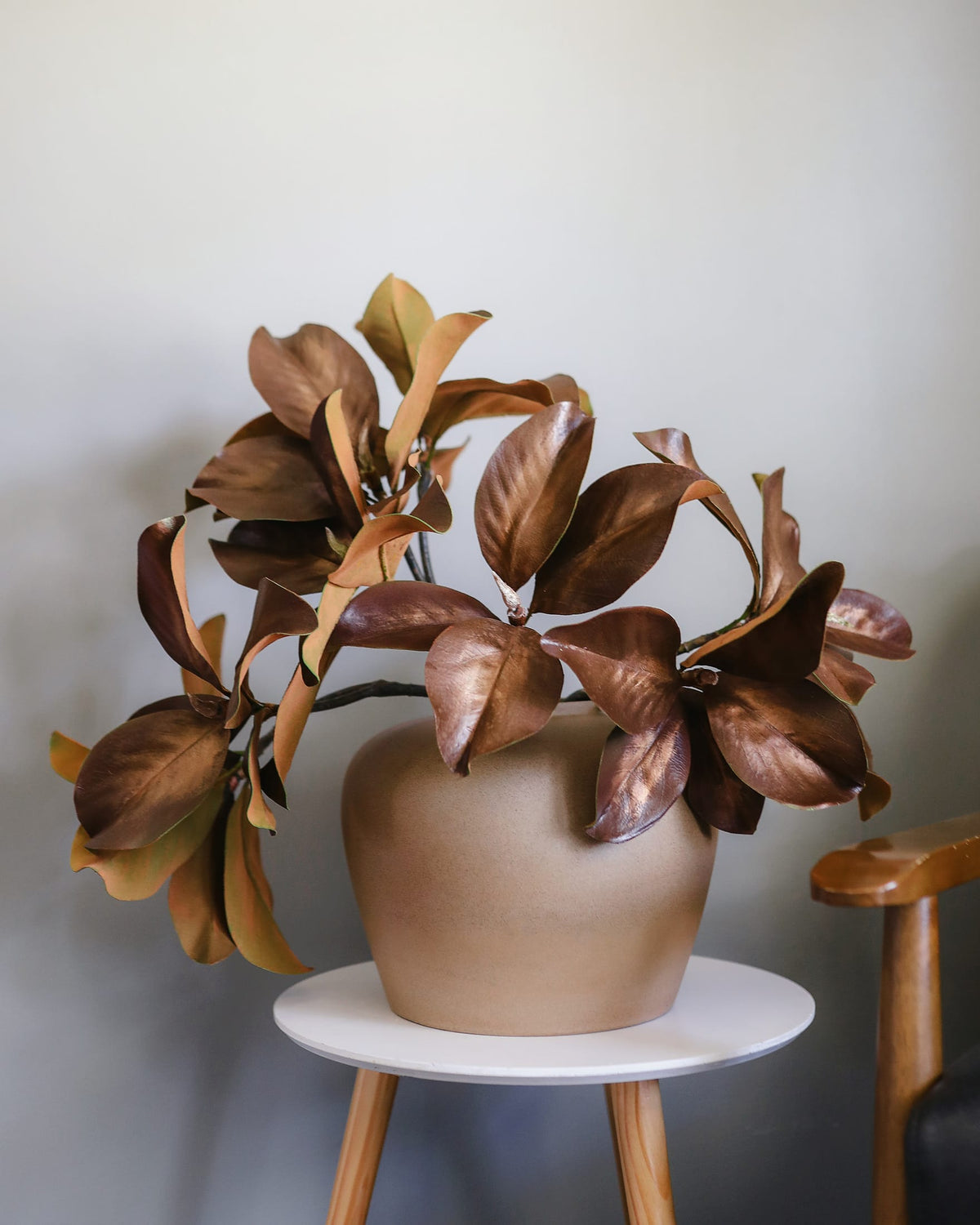 Bronze-colored faux magnolia stems in a vase