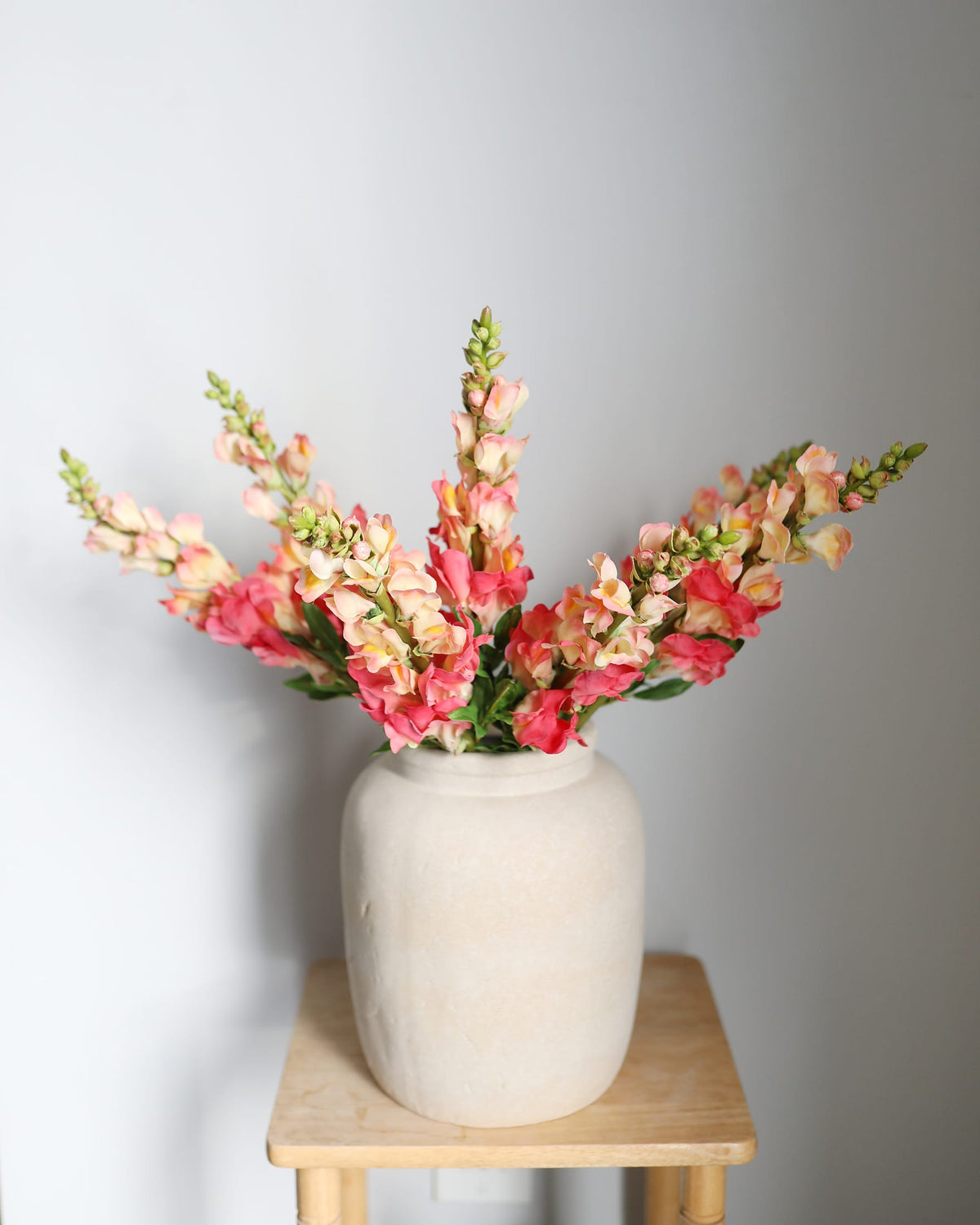 faux coral snapdragon stems in a vase 