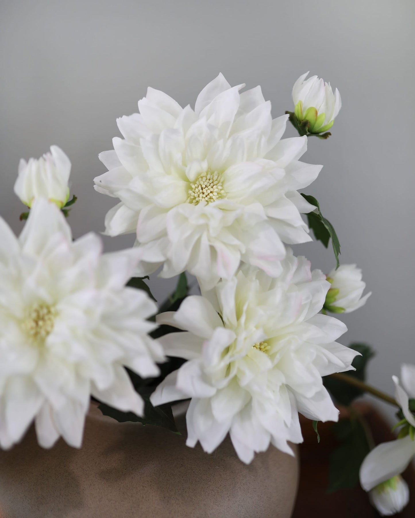 White faux dahlias with a blurred background