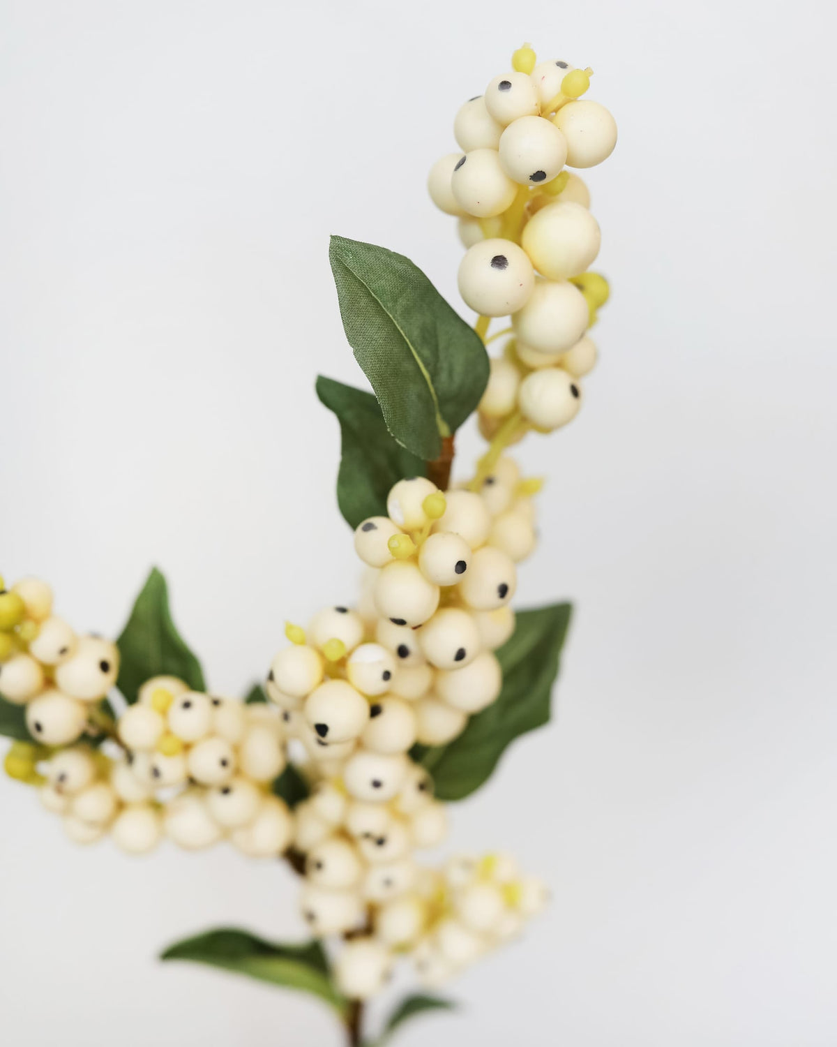 faux snowberries on a light gray background