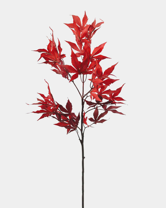 A single artificial red maple leaf stem with realistic leaf clusters and a dark brown stem, isolated on a light gray background.