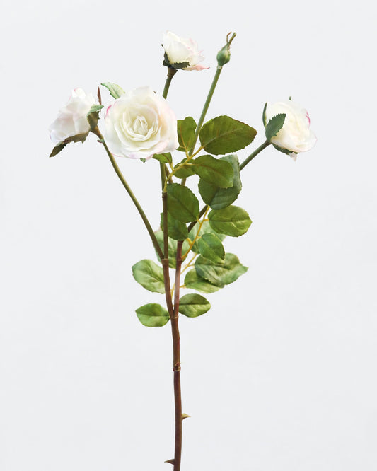 An artificial rose stem featuring three white roses, two buds, and green leaves on a solid light gray background.