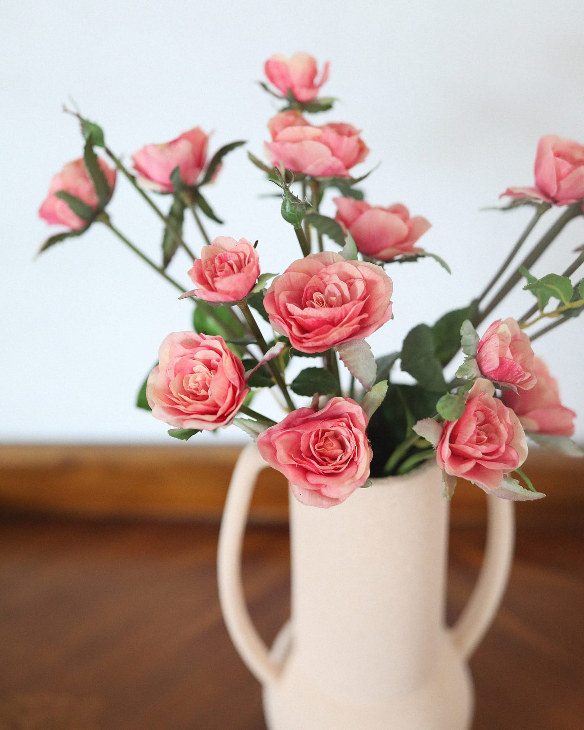 artificial pink rose spray close up in a vase