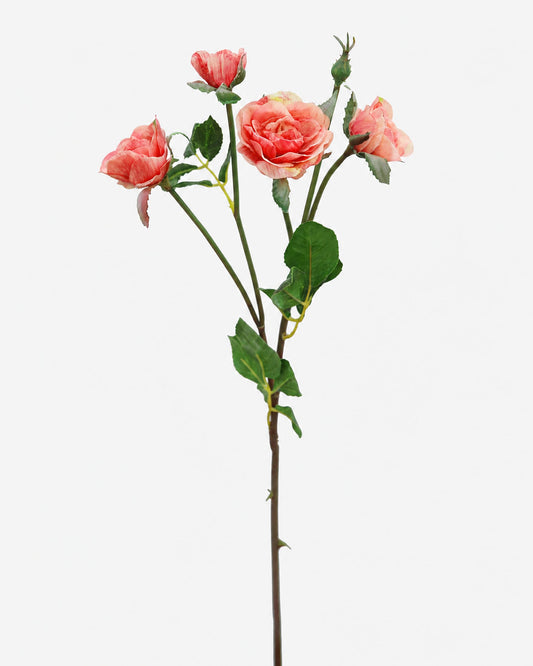 An artificial rose stem with three pinkish-orange roses, green leaves, and brown stems, photographed against a solid white background.