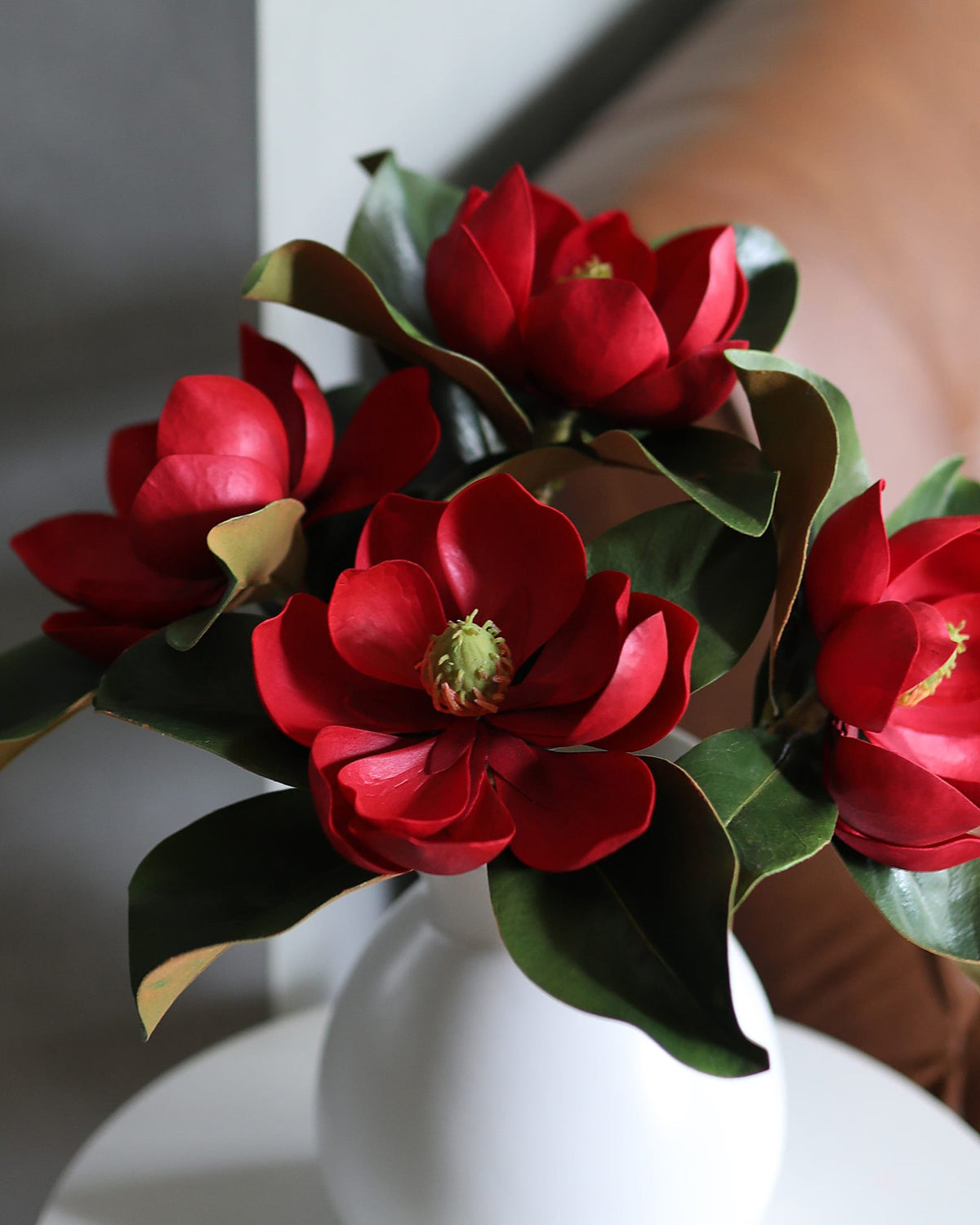 Red artificial Magnolias in a vase