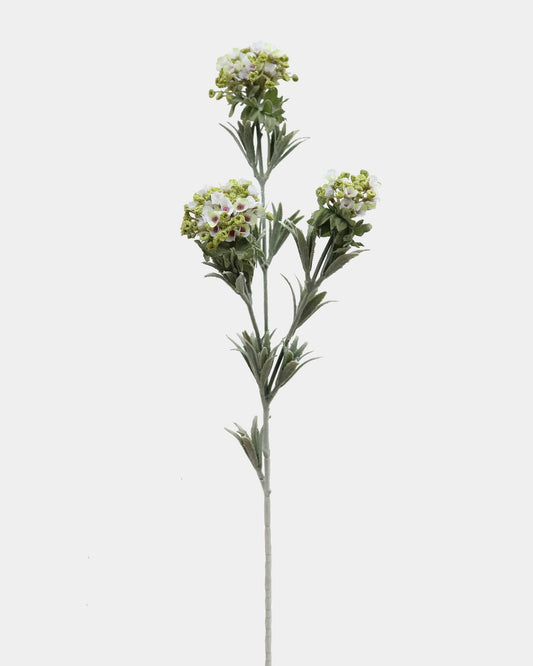 Artificial flower stem with green leaves and white flowers on a light gray background