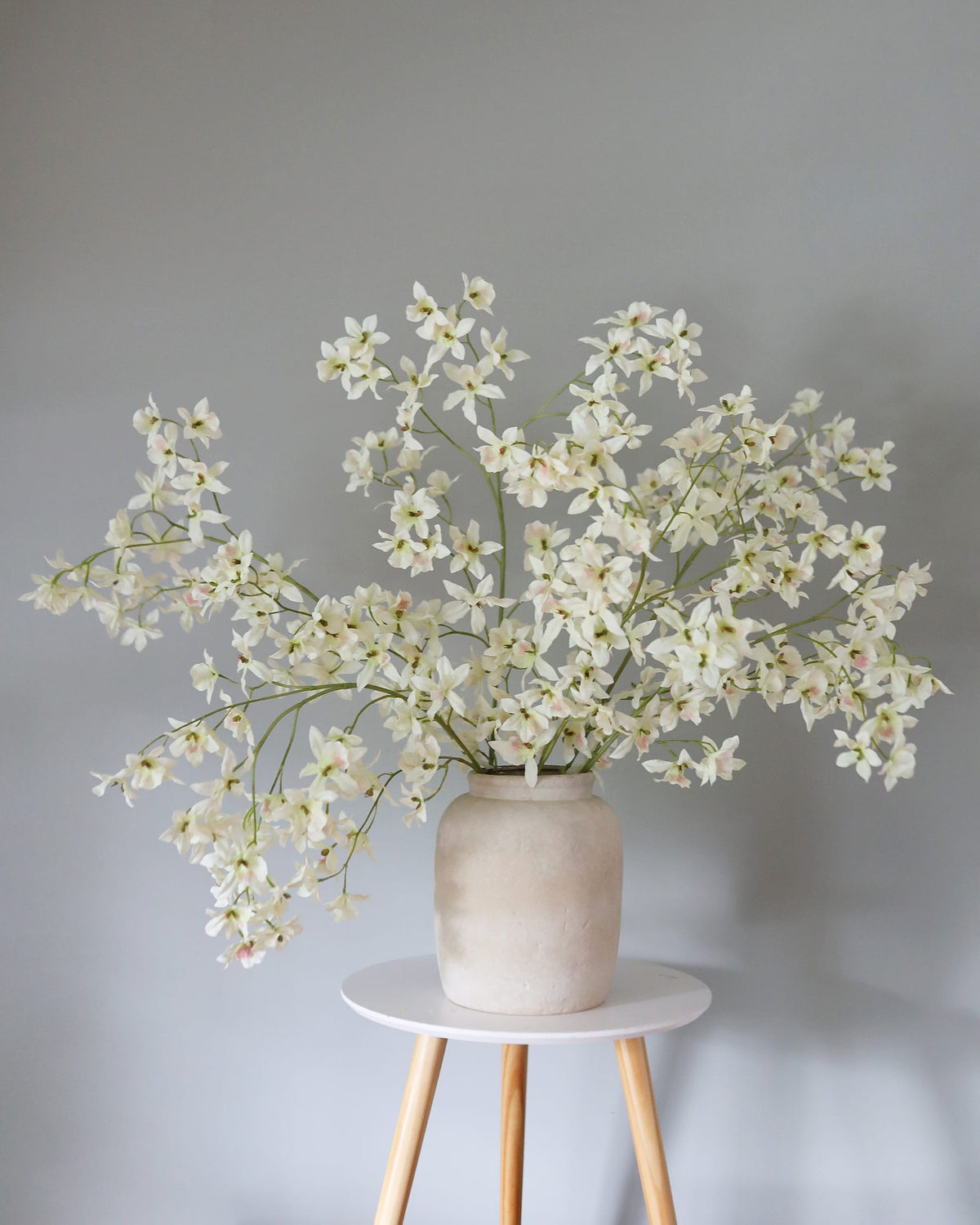 Artificial White Oncidium orchids in a vase