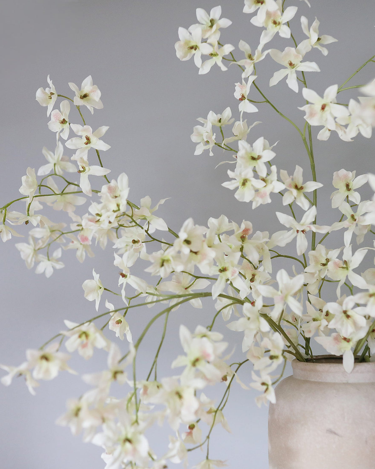Artificial White Oncidium orchid stems in a vase