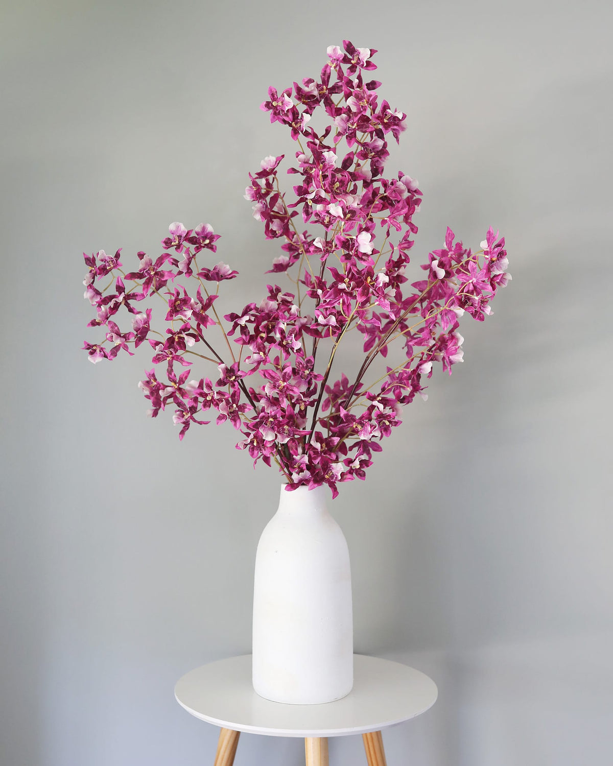 Pink artificial oncidium stems in a vase 