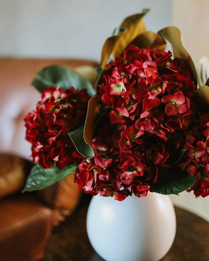 Close Up of Flower Arrangement Made with Hydrangeas in Red and Artificial Magnolia Leaves