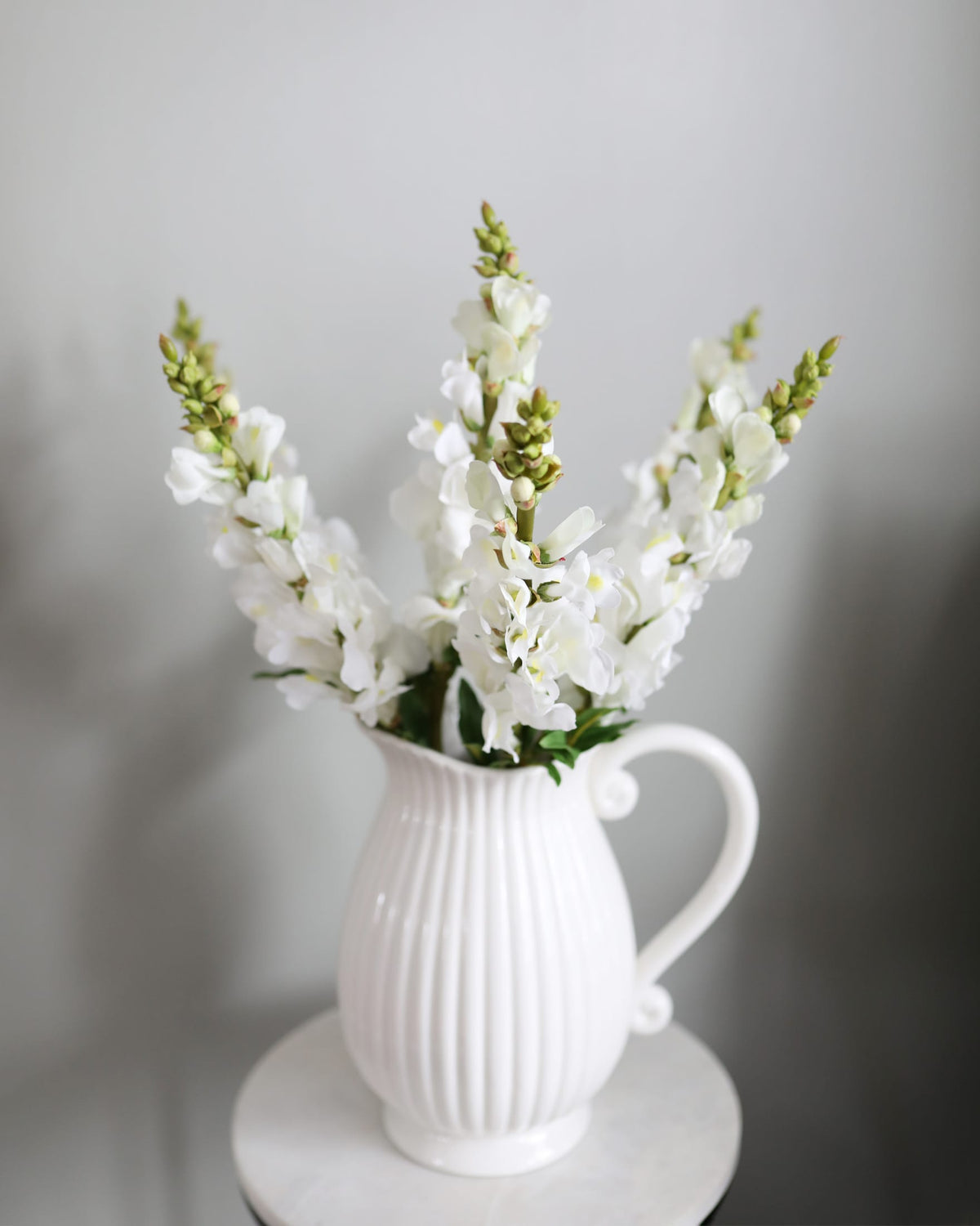 faux white snapdragons in a vase