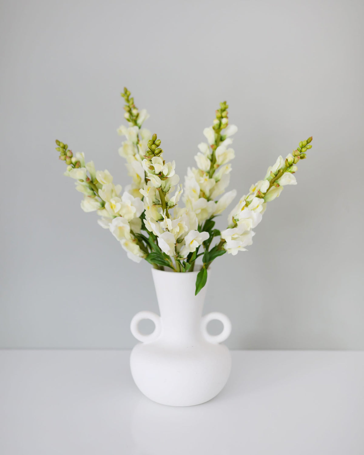 faux yellowish snapdragons in a vase